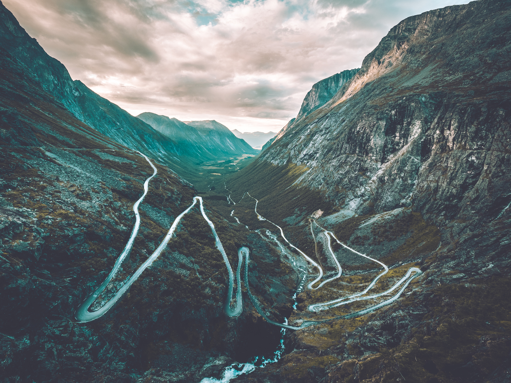 "Trollstigen, or the Troll's Path, is a winding mountain road in Norway known for its stunning views and hairpin turns. This image captures the rugged beauty of the Norwegian landscape and the majesty of the mountains surrounding Trollstigen." "Experience the awe-inspiring beauty of Trollstigen in Norway with this breathtaking image. The winding road, towering peaks, and lush greenery all come together to create a truly unforgettable scene." "Looking for adventure and natural beauty? Look no further than Trollstigen in Norway! This image showcases the dramatic landscape of the region, including the steep cliffs, plunging valleys, and winding mountain road."